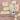 Collection of bath soaks, candles, and a pen on a textured pink surface