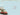 Red convertible car with Christmas tree on a snowy landscape, festive text overlay.