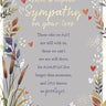 Sympathy card with floral design and text on a gray background