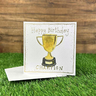Gold trophy with writing 'happy birthday champion'