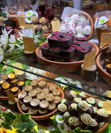 Display of various chocolate truffles and candies with decorative elements.