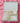 Gift box with baby items including a onesie, blanket, and toys on a pink textured background