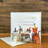 Cats holding birthday cake wearing party hats. 'happy birthday to my favourite human, lots of miaows and kisses'.